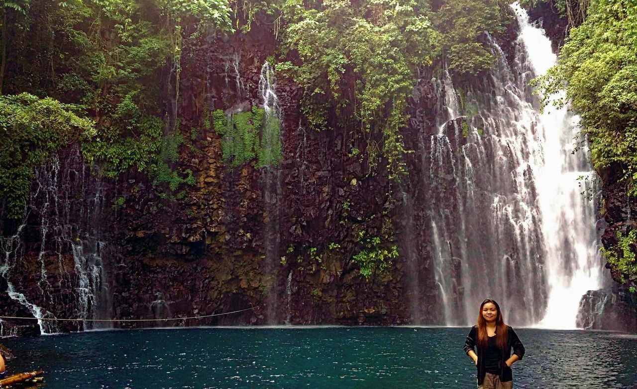 Portrait of woman standing against tinago falls