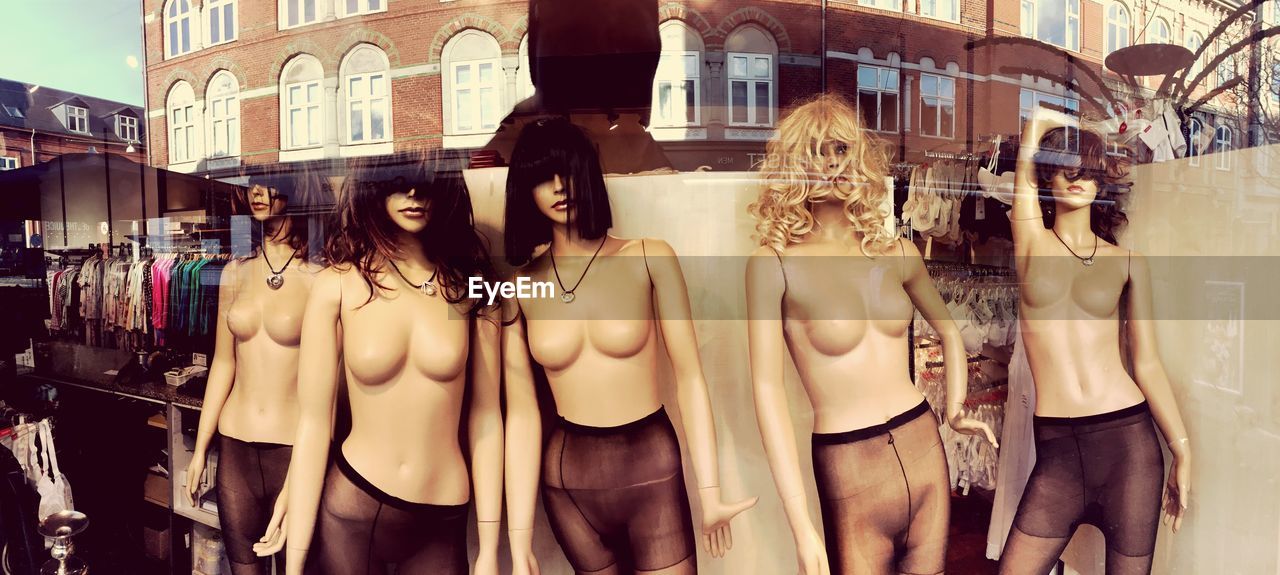Mannequins in store seen through glass