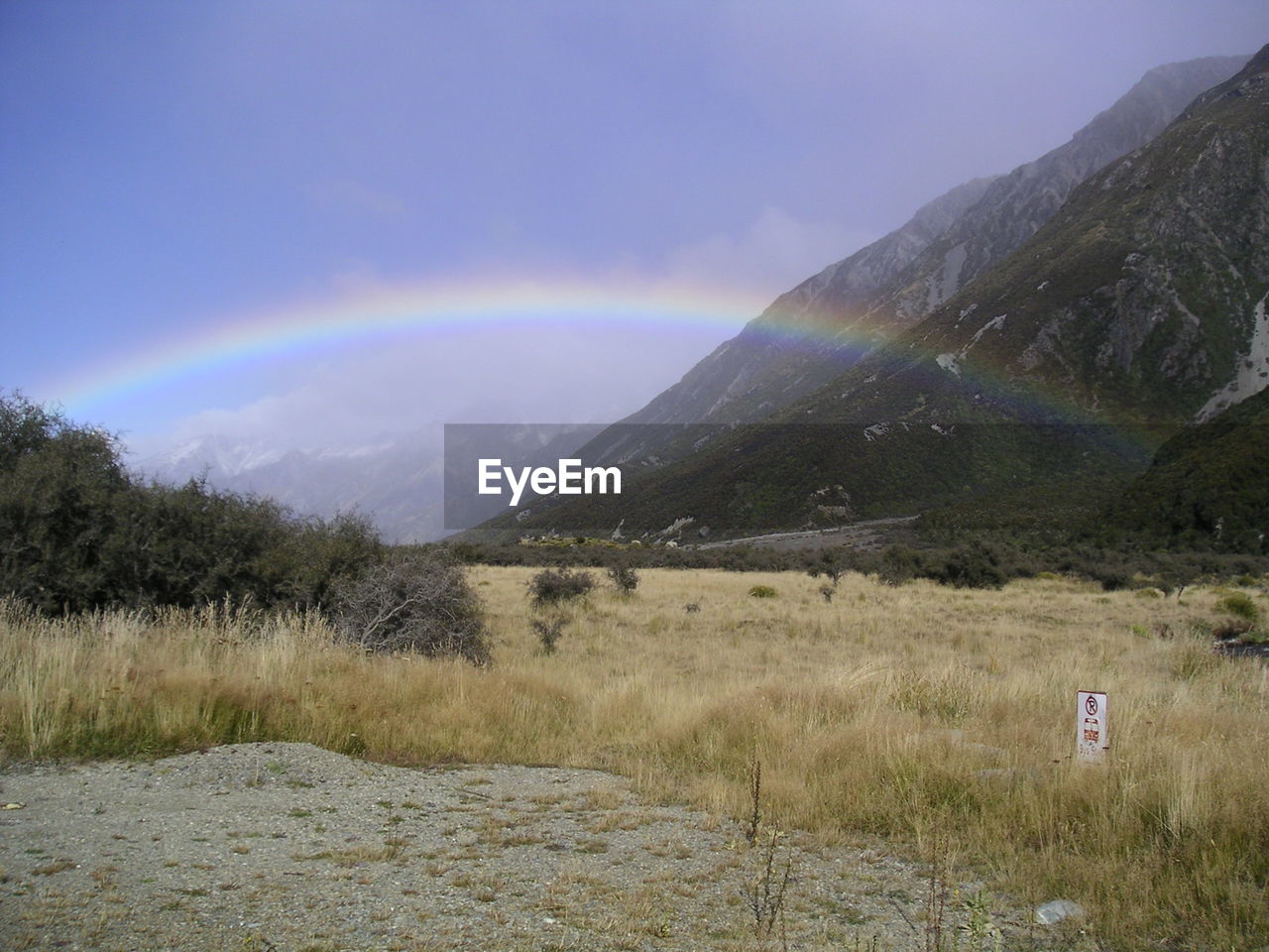 Scenic view of rainbow over grassy field