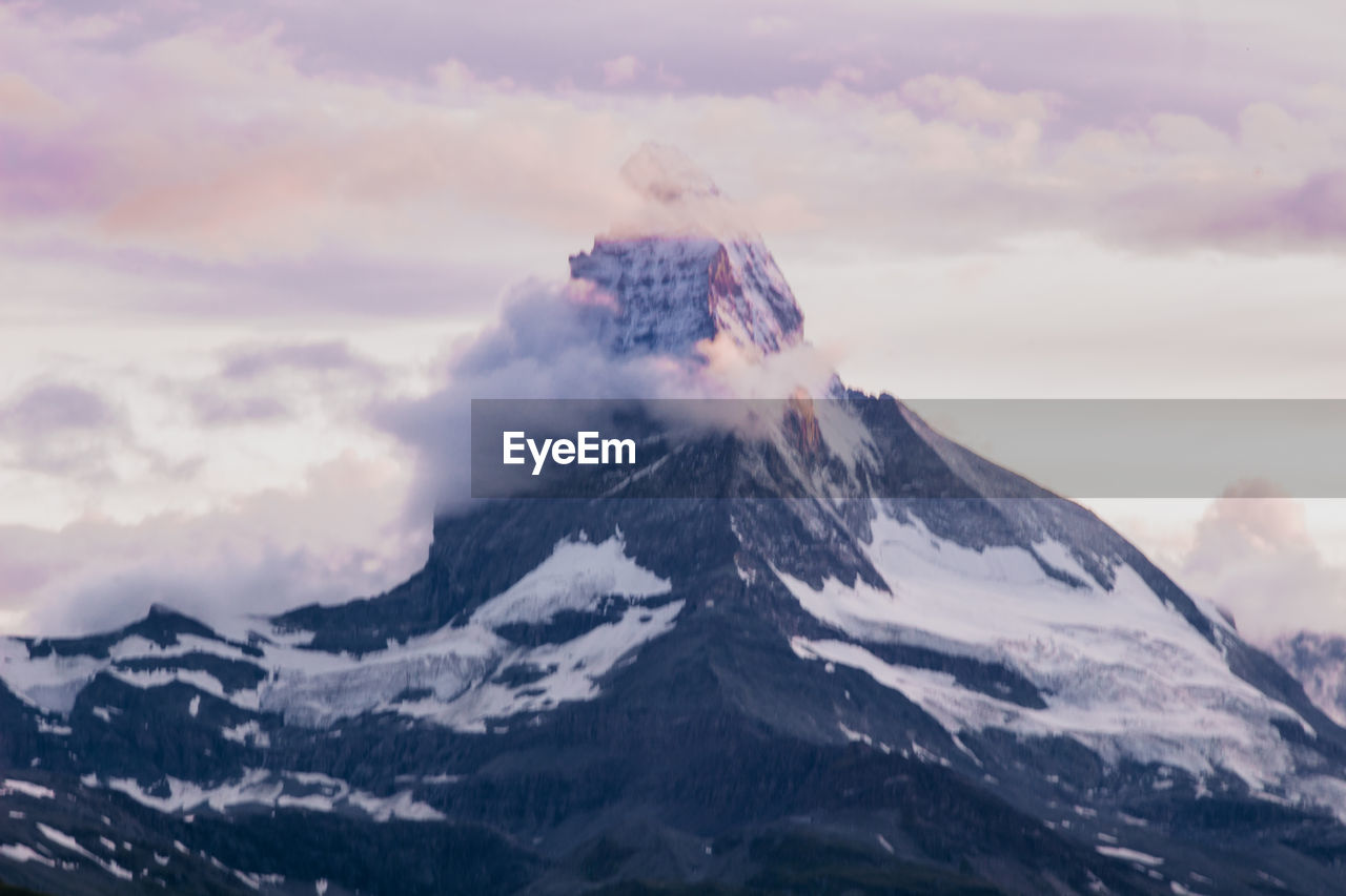 Scenic view of snowcapped mountains against sky during sunset