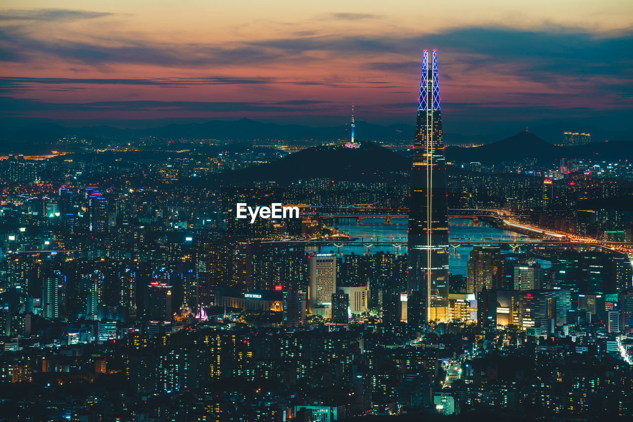 Illuminated cityscape against sky at night