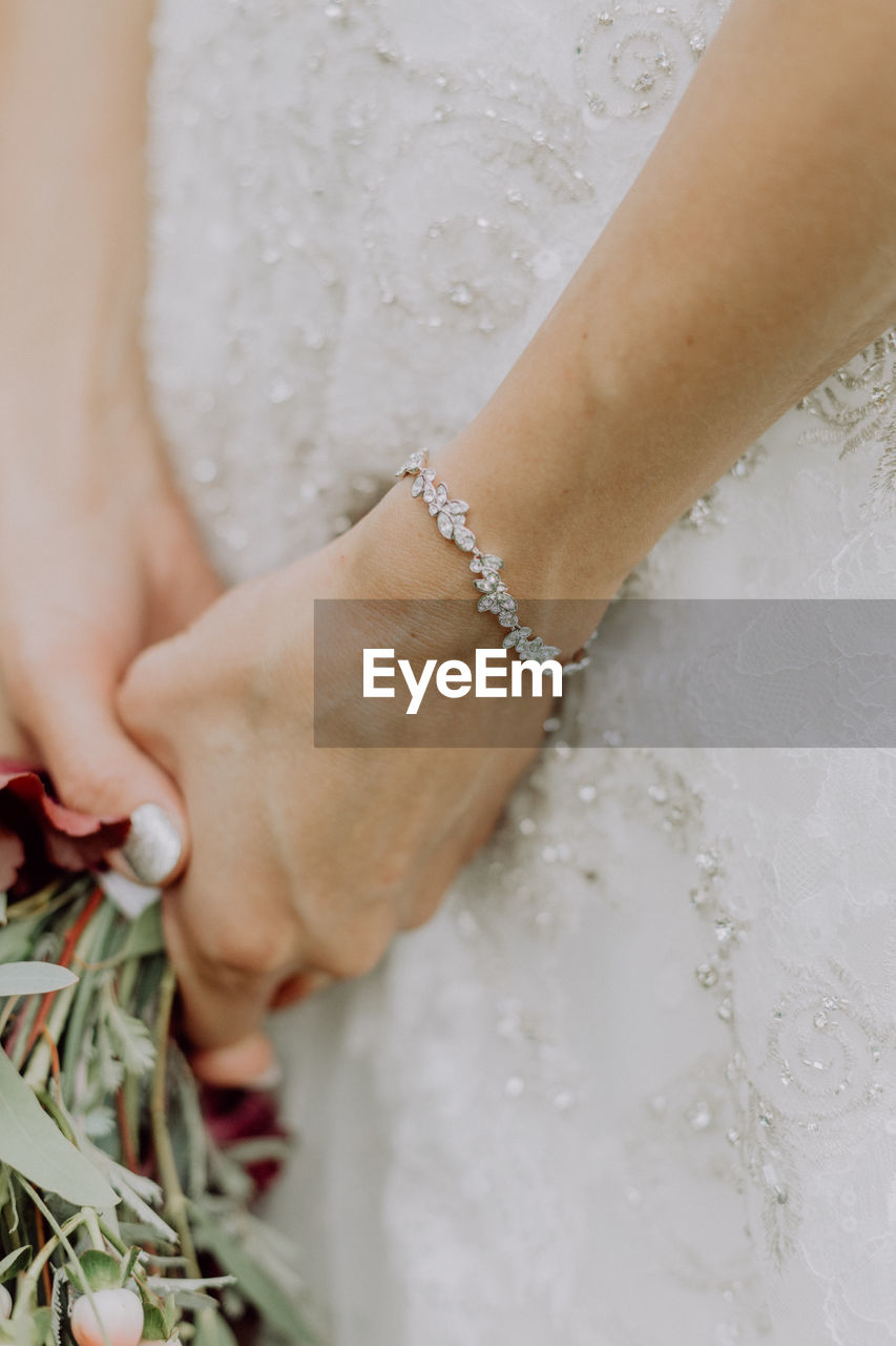 Midsection of bride holding bouquet