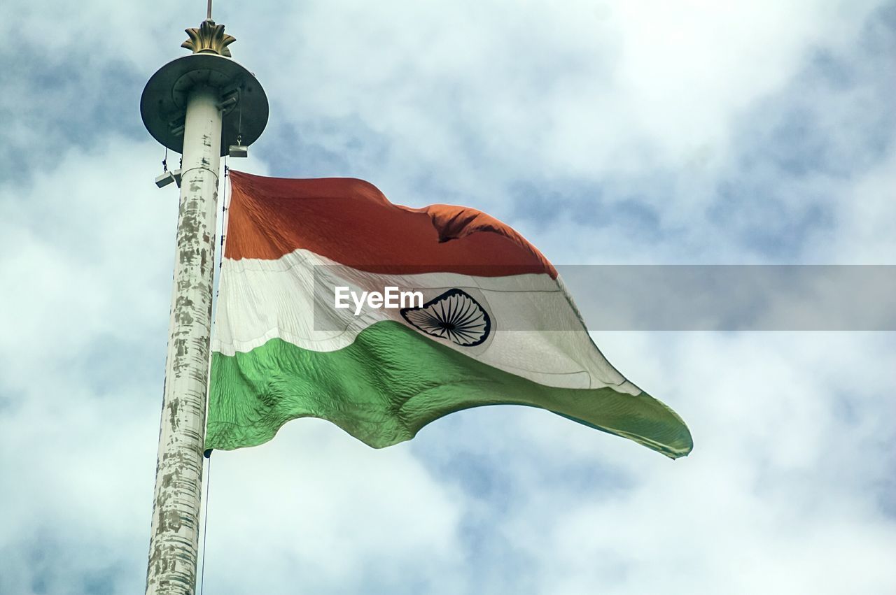 Low angle view of indian flag waving against cloudy sky