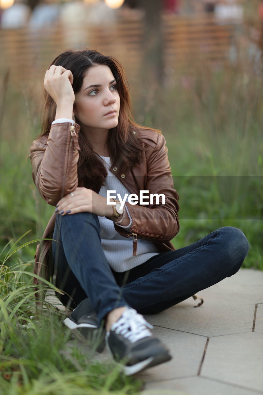 Full length of young woman sitting outdoors