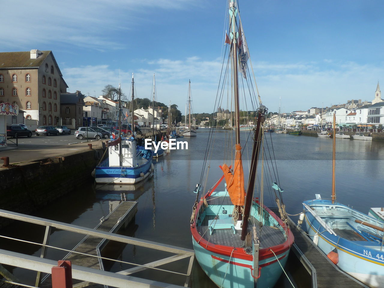 Sailboats moored at harbor