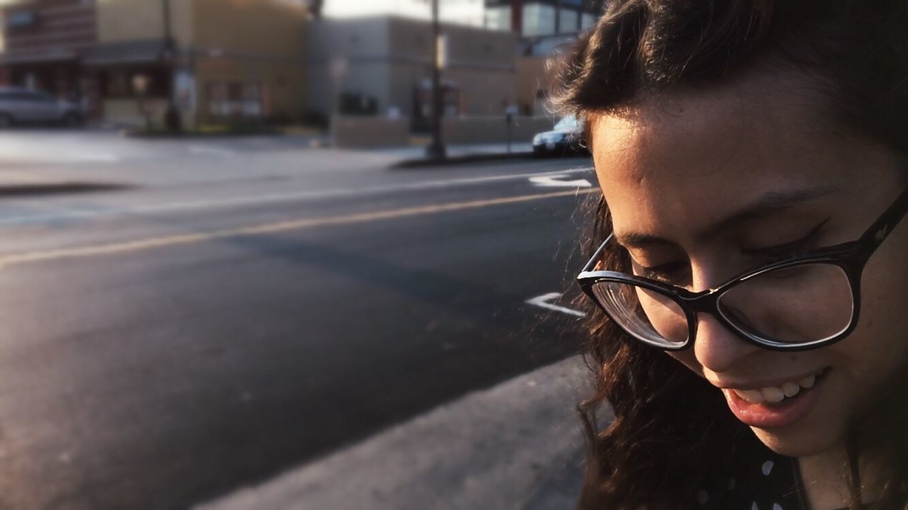 Close-up of smiling woman with eyeglasses on road