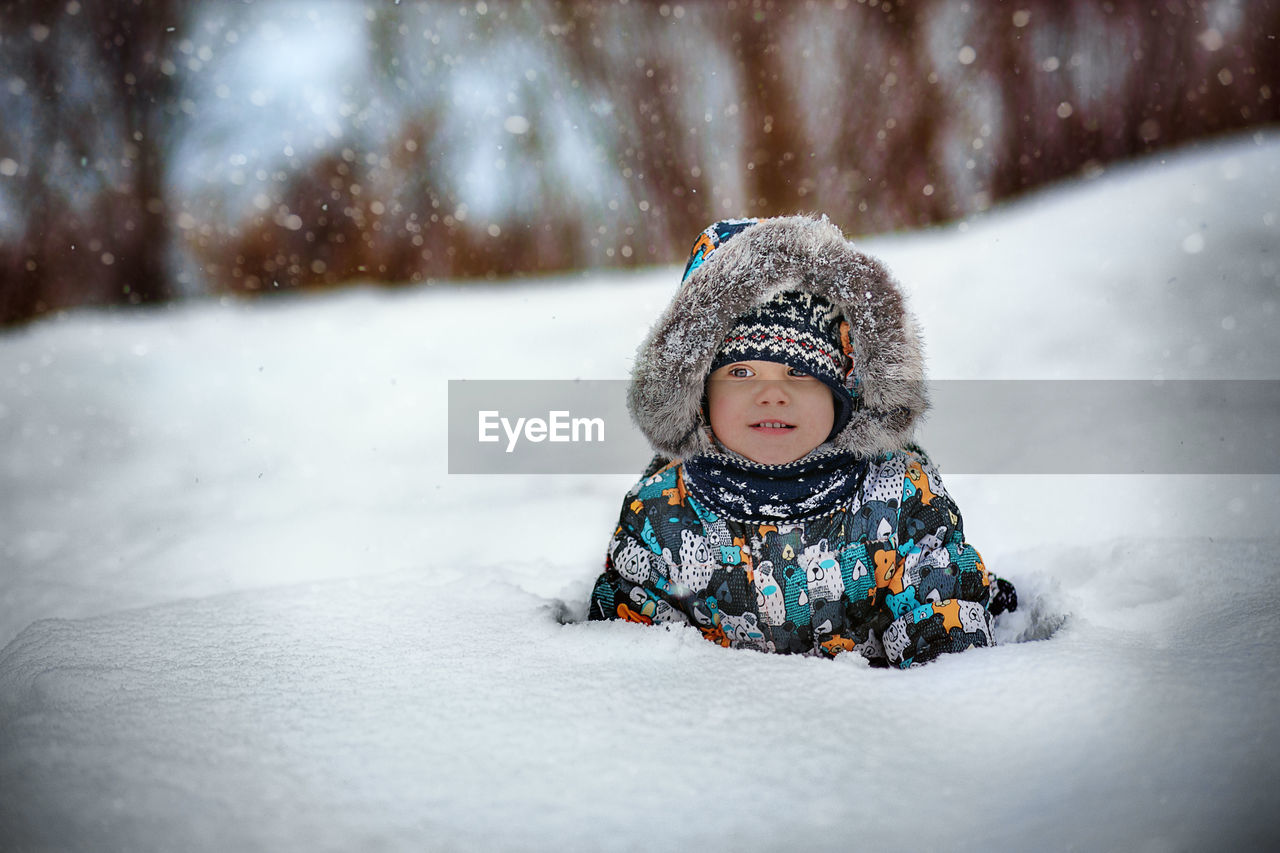 portrait of smiling young woman skiing on snow covered field