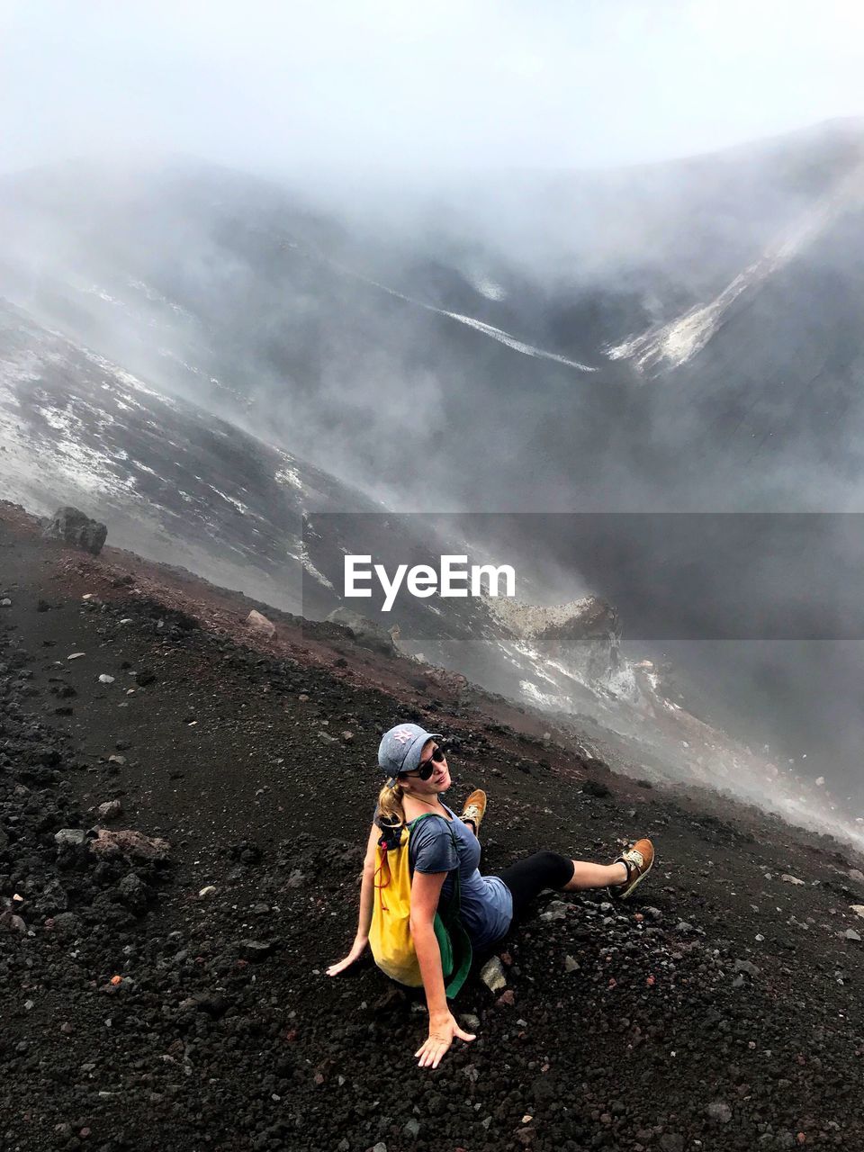 Woman sitting at volcanic crater