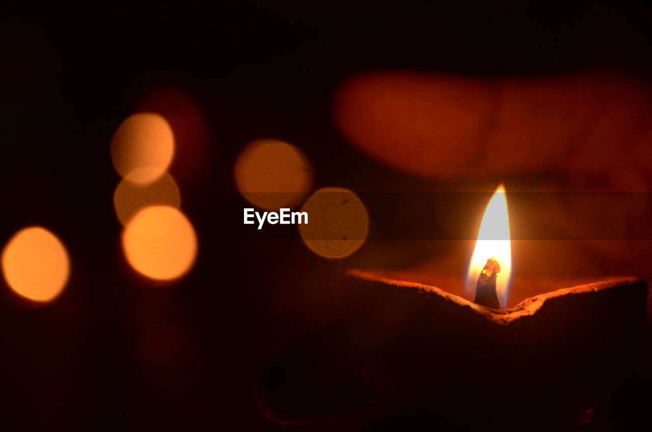 Close-up of hand holding diya at night