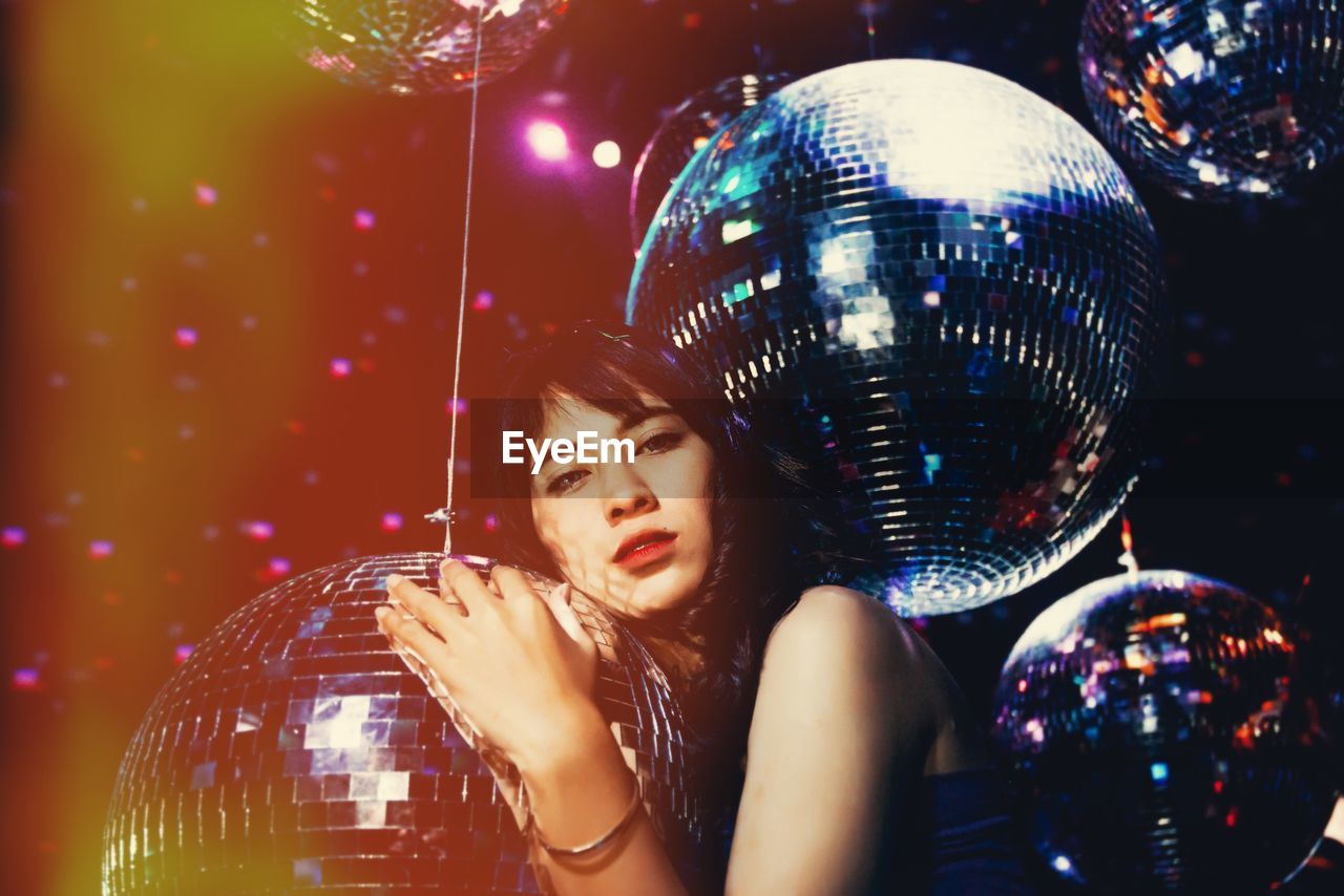 Young woman with disco balls in nightclub