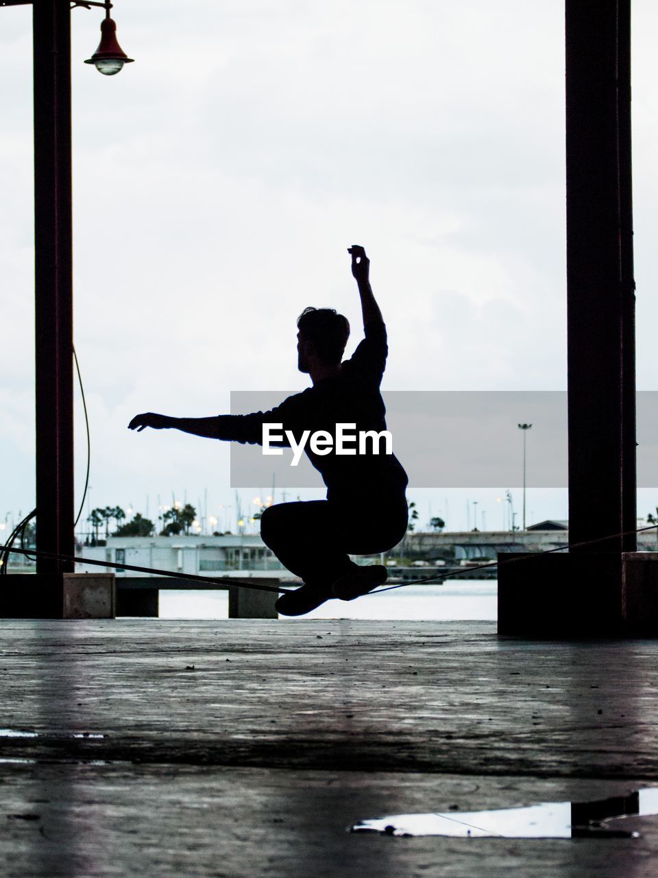 Man with arms raised against sky