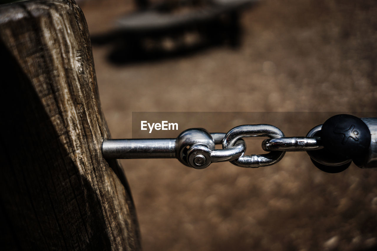 Close-up of chain on wood