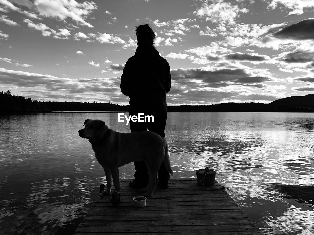 SILHOUETTE DOG ON LAKE AGAINST SKY