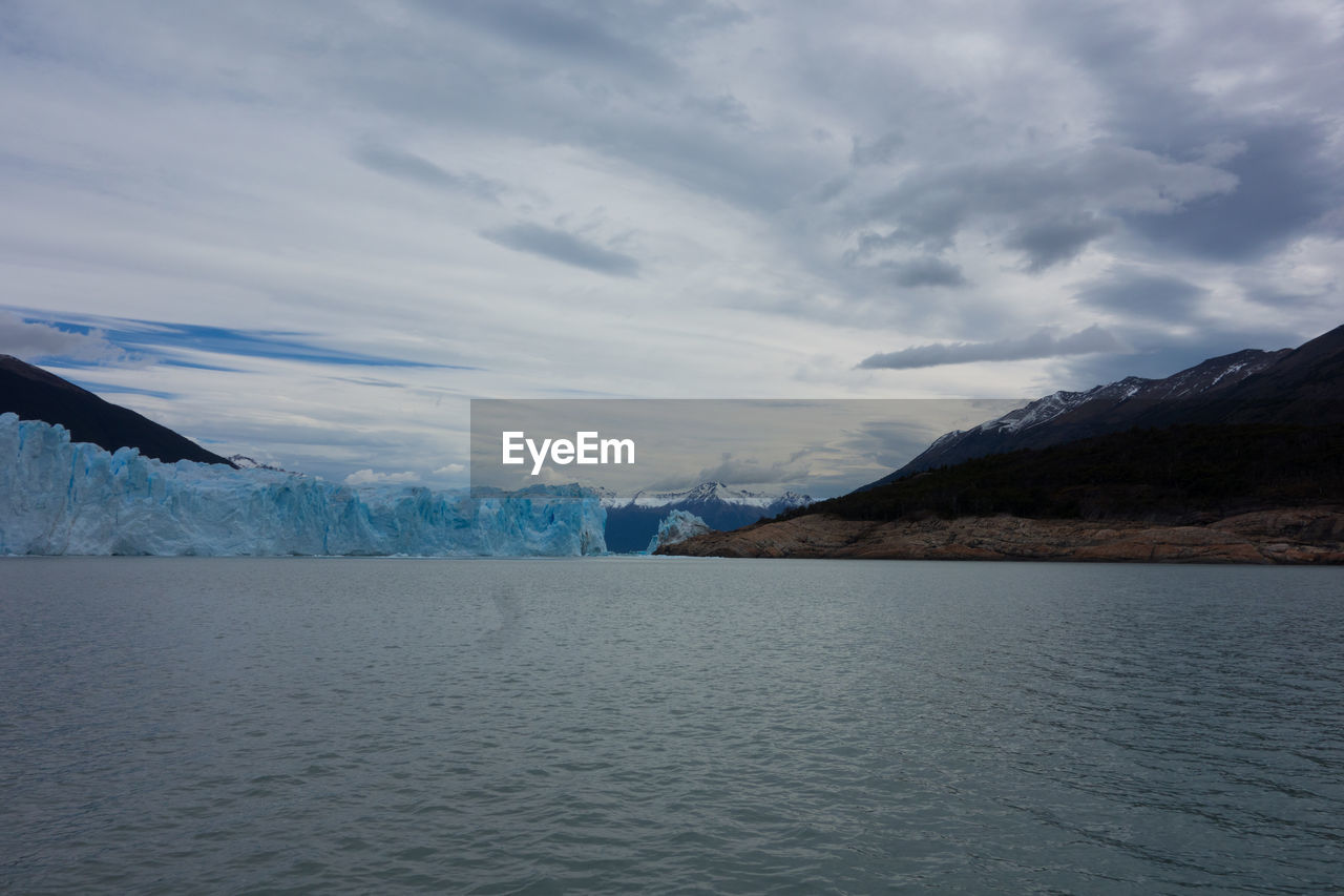 SCENIC VIEW OF LAKE AGAINST SNOWCAPPED MOUNTAINS