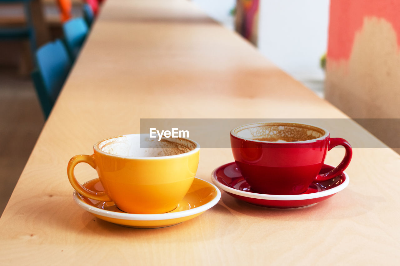 Two cups of coffee on wooden table in cafe.