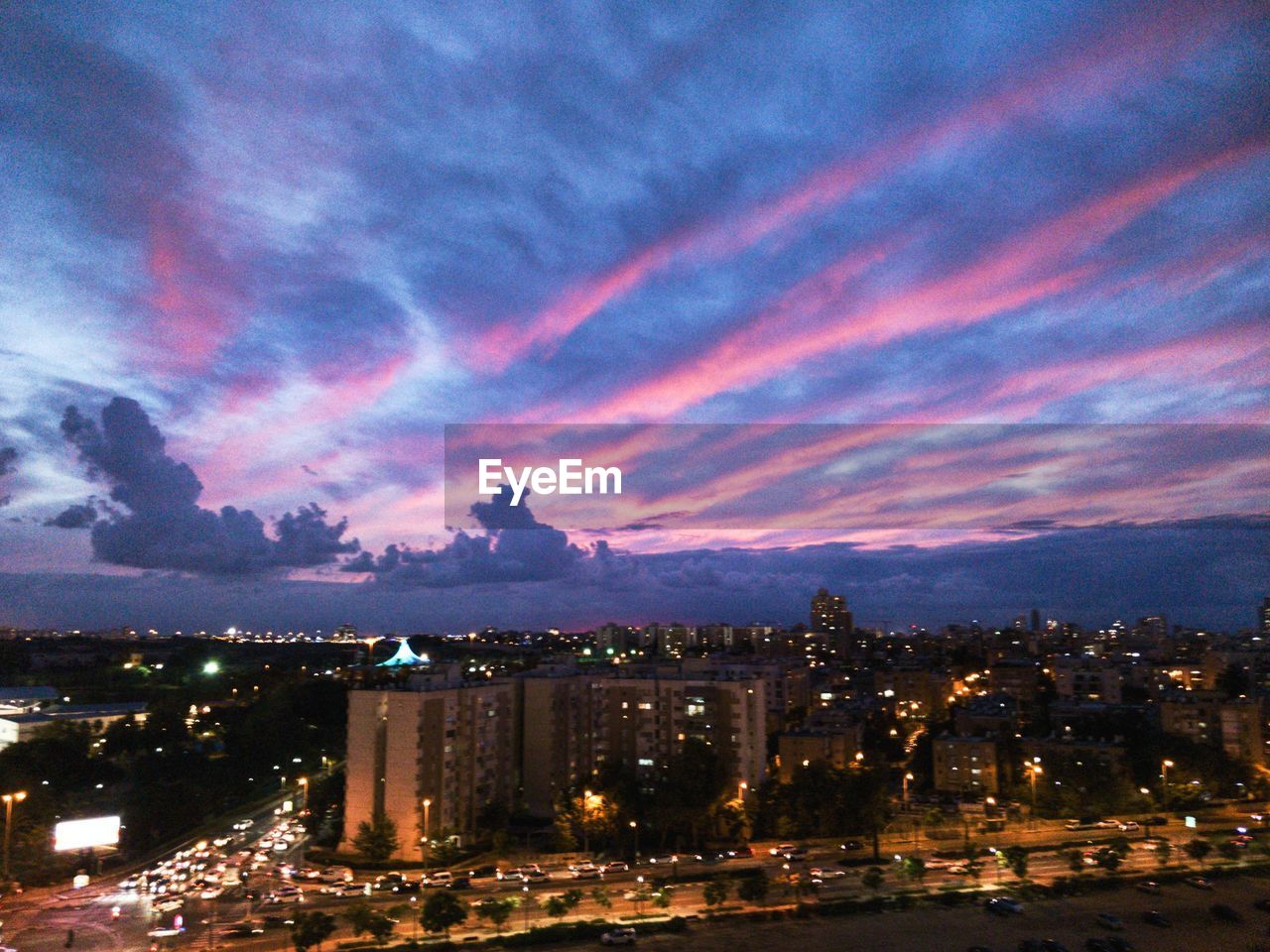 HIGH ANGLE VIEW OF ILLUMINATED BUILDINGS AT NIGHT