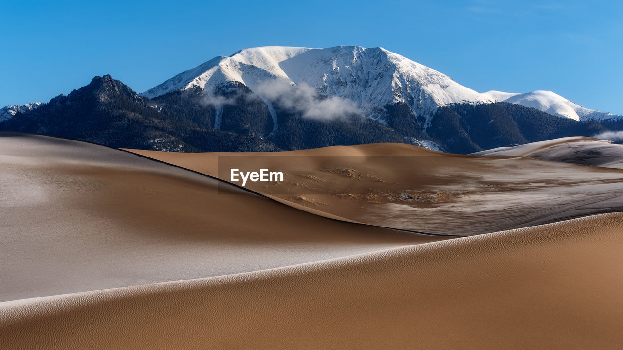 Scenic view of desert against blue sky