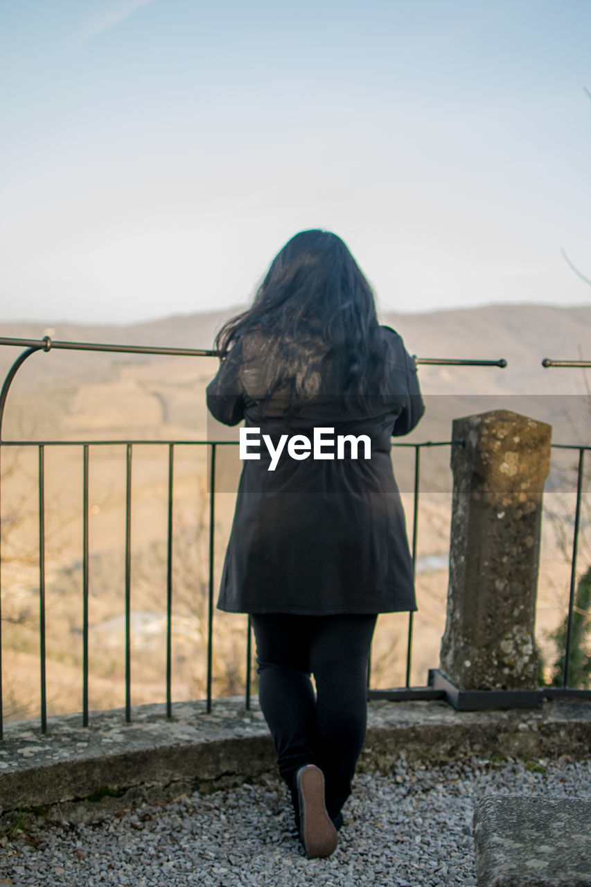 Rear view of woman standing against clear sky