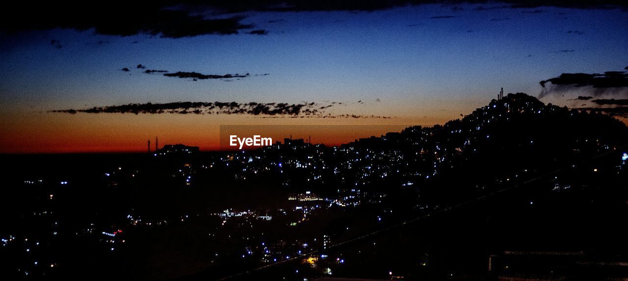 VIEW OF ILLUMINATED CITYSCAPE AT NIGHT