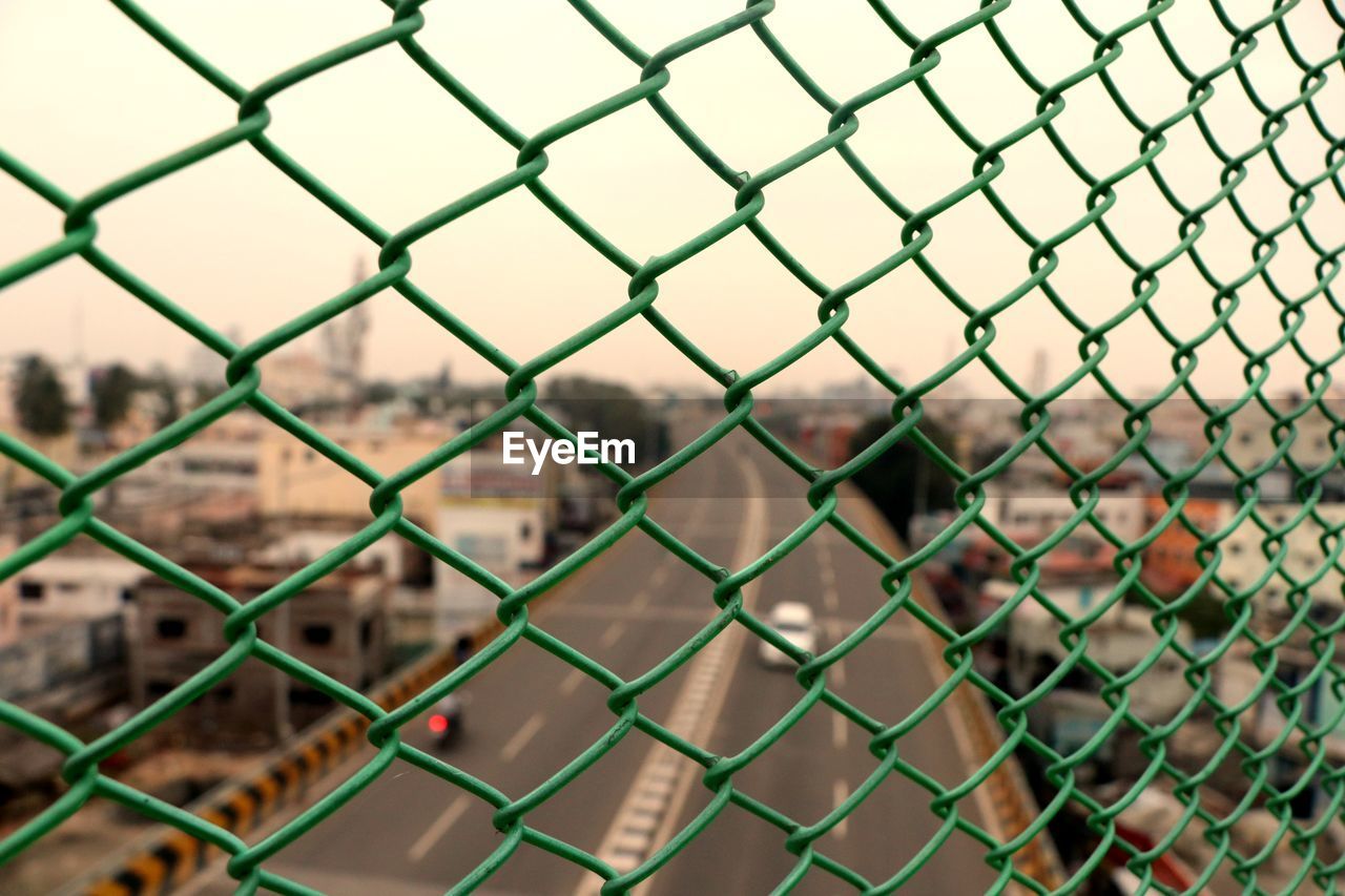 Full frame shot of chainlink fence against townscape