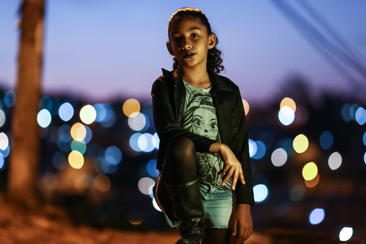 Portrait of girl standing outdoors at night 