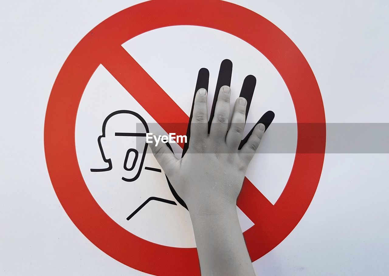Cropped hand touching information sign against white background