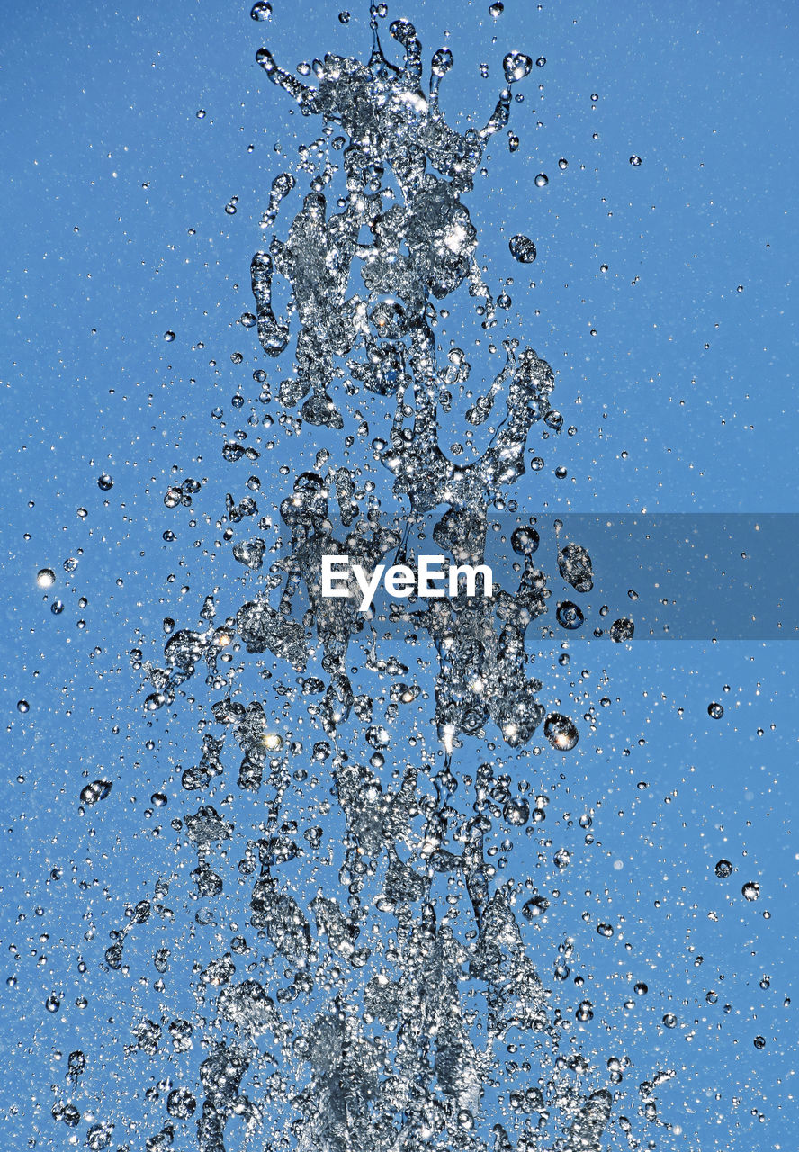 Close-up of water splashing against blue background