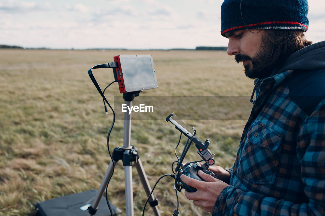 SIDE VIEW OF MAN PHOTOGRAPHING BICYCLE ON LAND