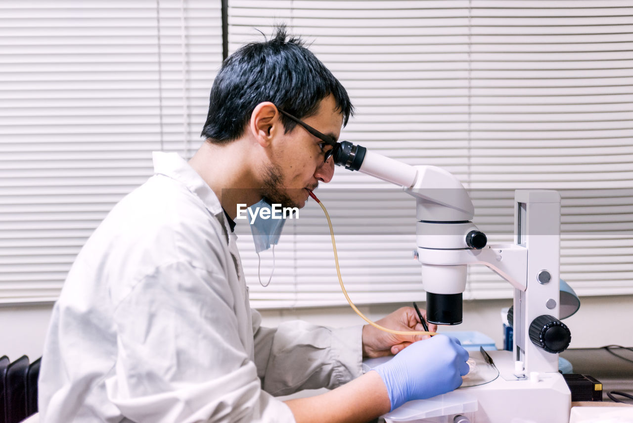 Male scientist using microscopy in laboratory