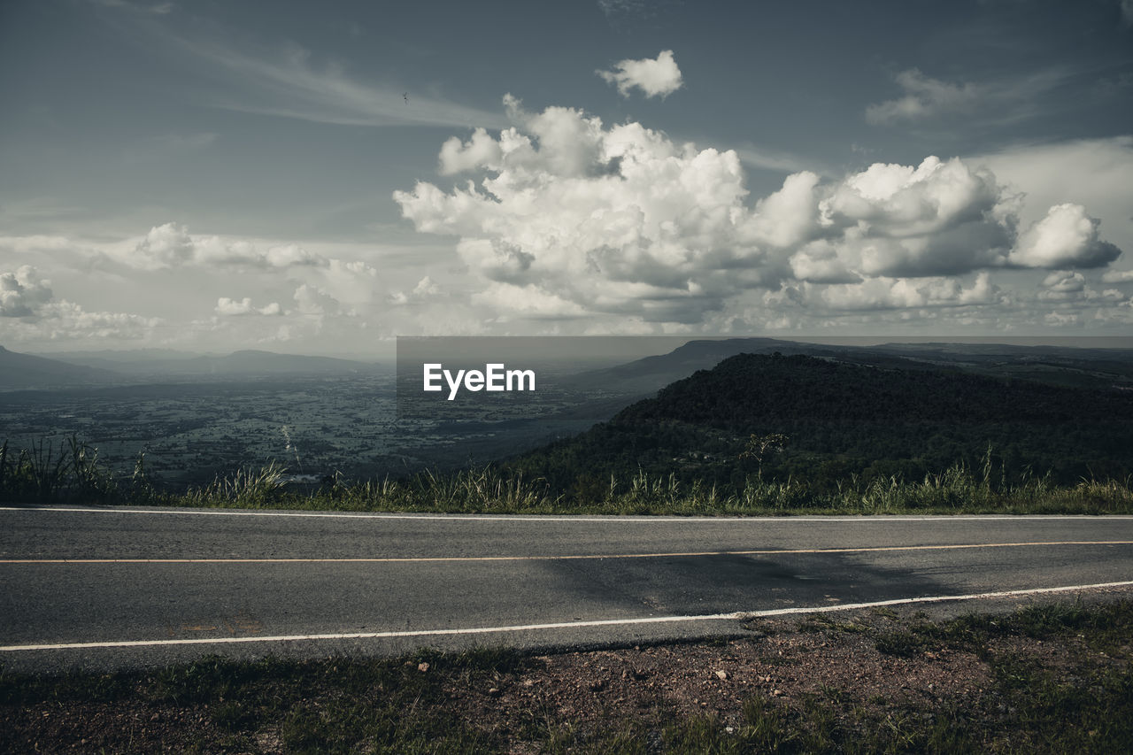 ROAD BY MOUNTAINS AGAINST SKY