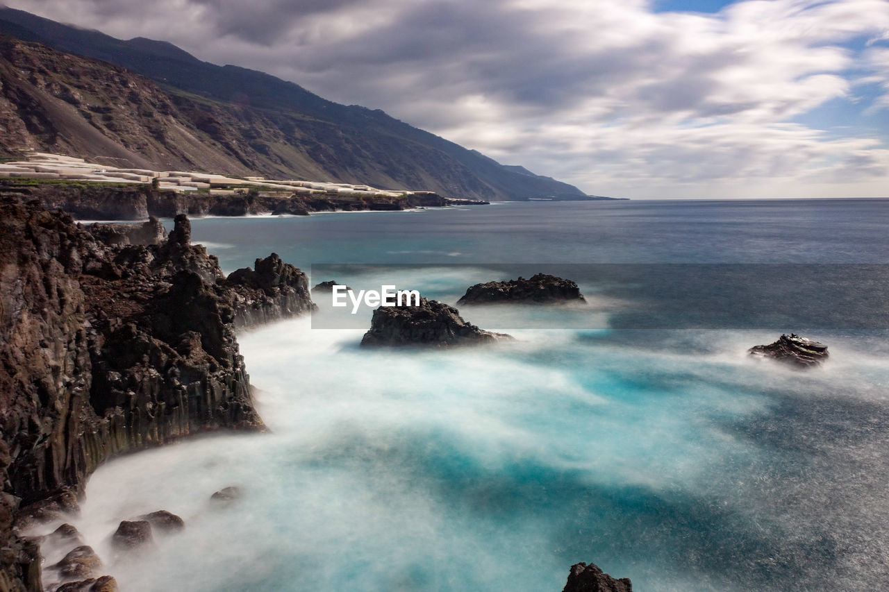 SCENIC VIEW OF SEA AND MOUNTAIN AGAINST SKY