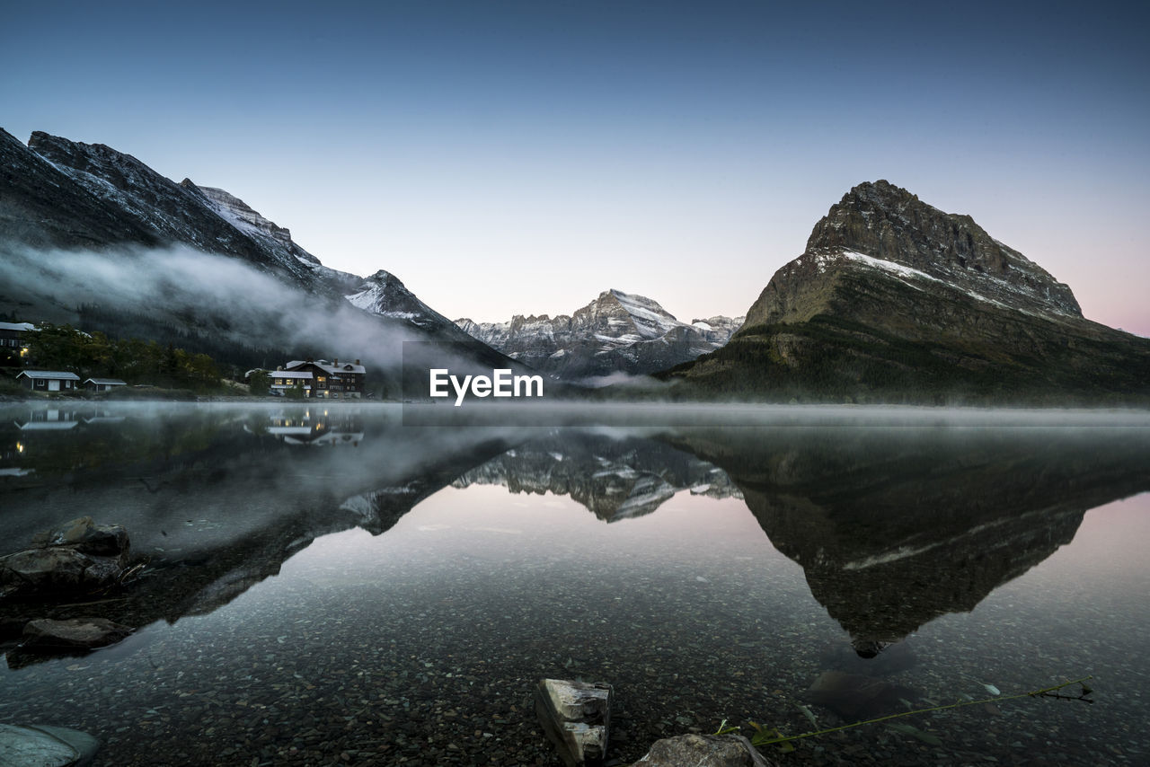 Scenic view of lake and mountains against clear sky