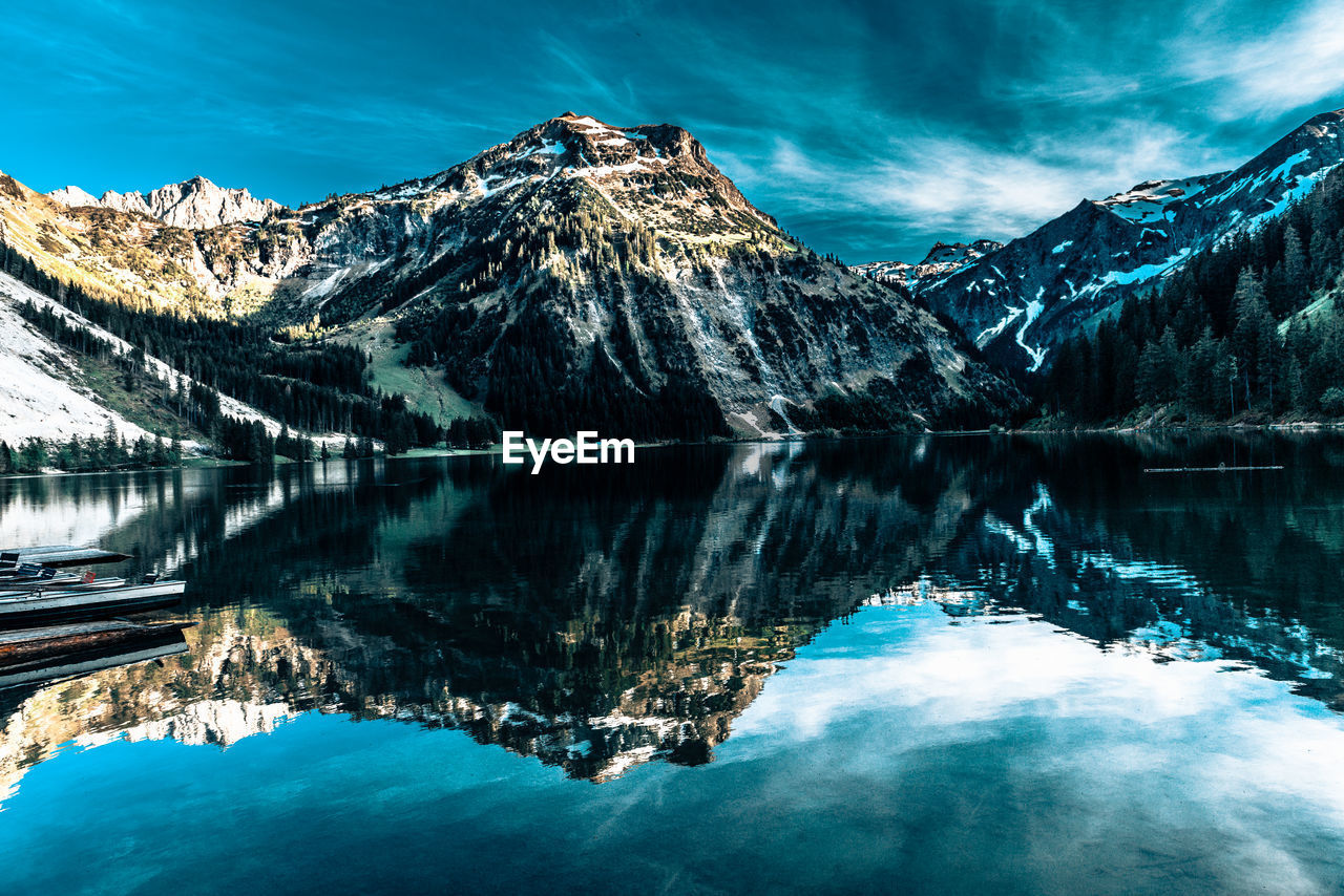 Scenic view of lake and snowcapped mountains against sky