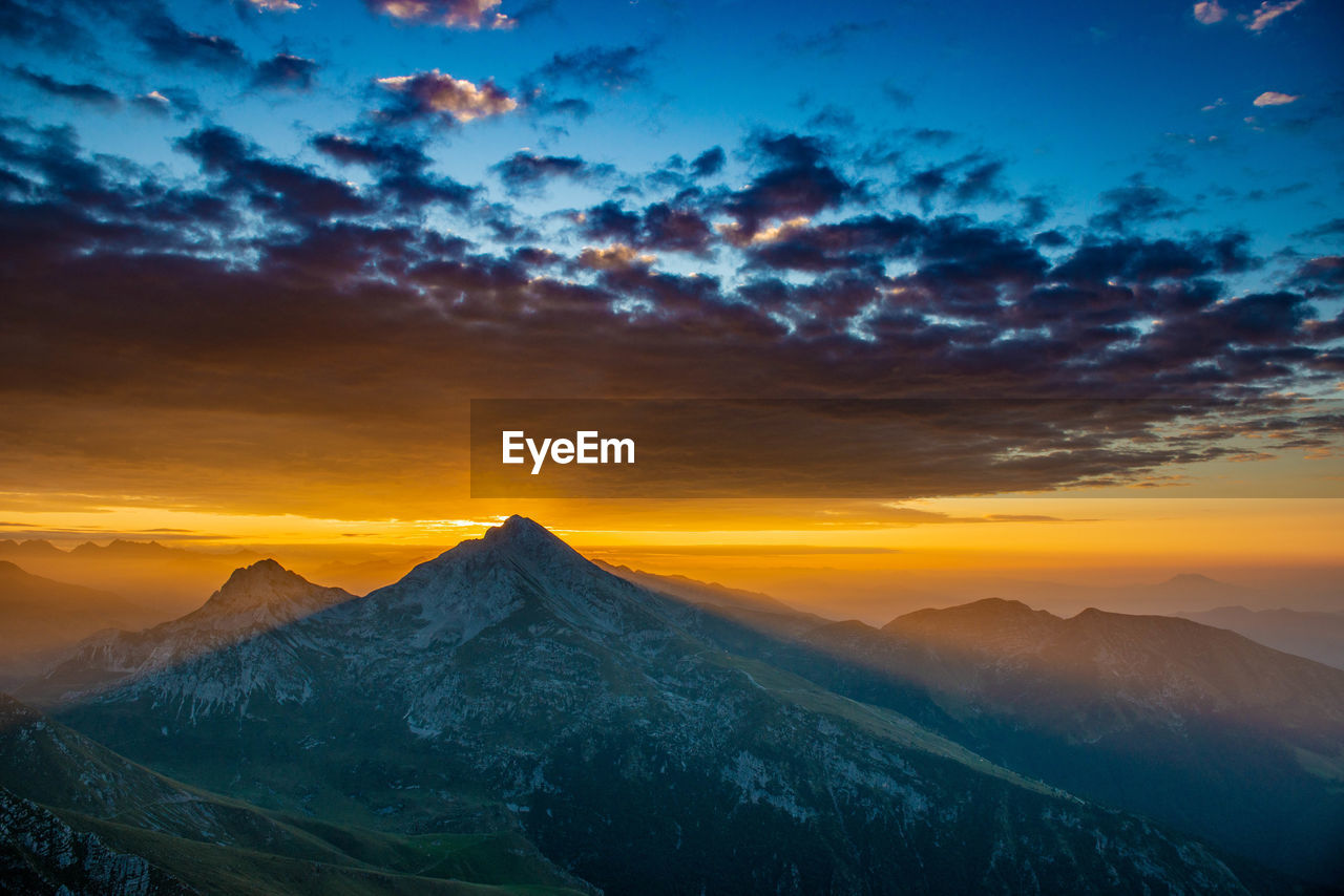 Scenic view of snowcapped mountains against sky during sunset