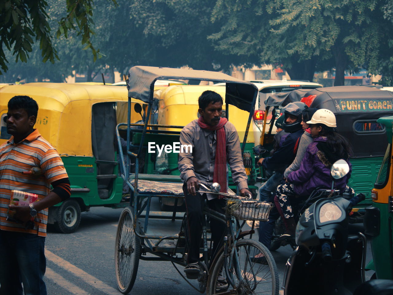 People riding old bicycle on road