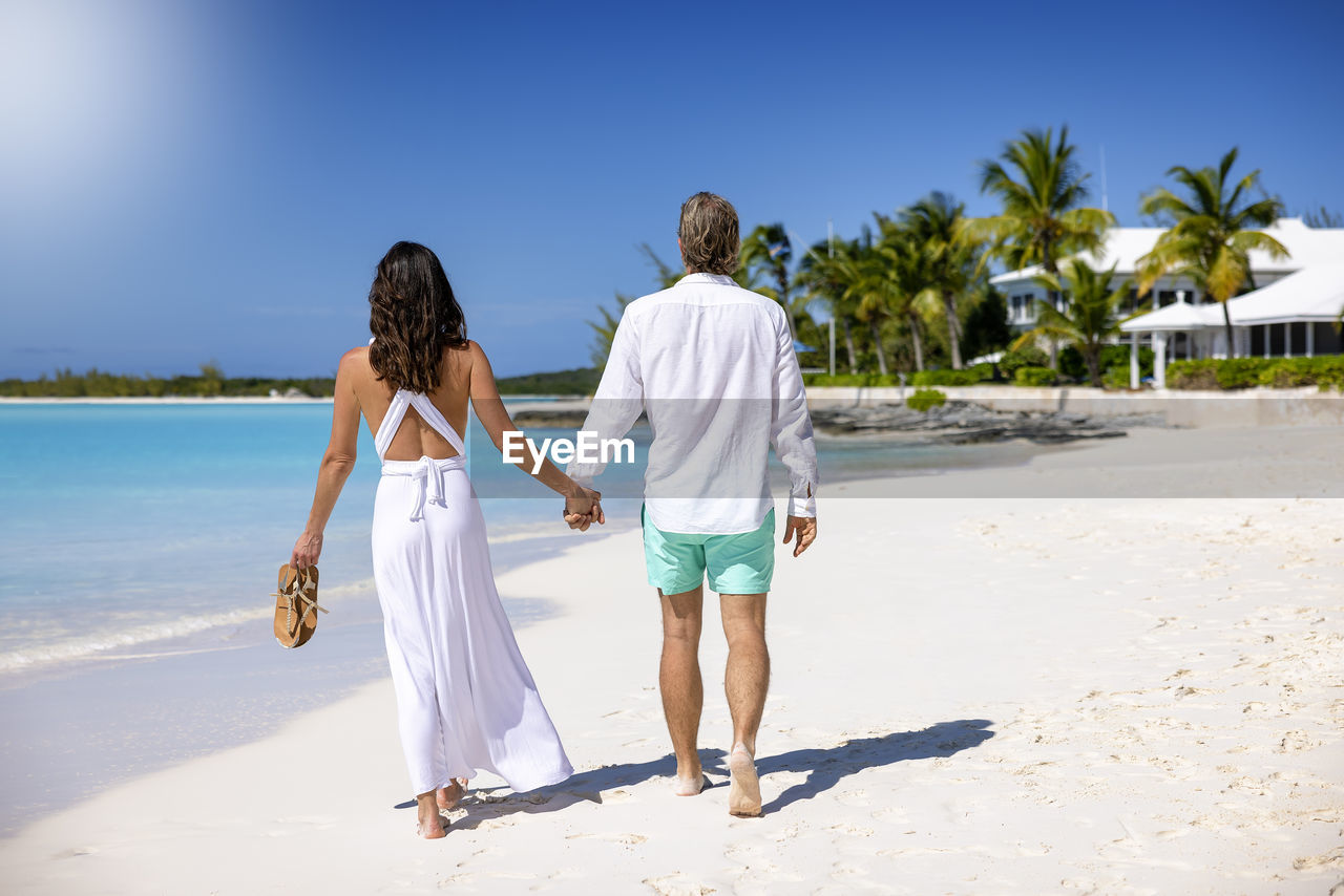 Rear view of couple walking on beach