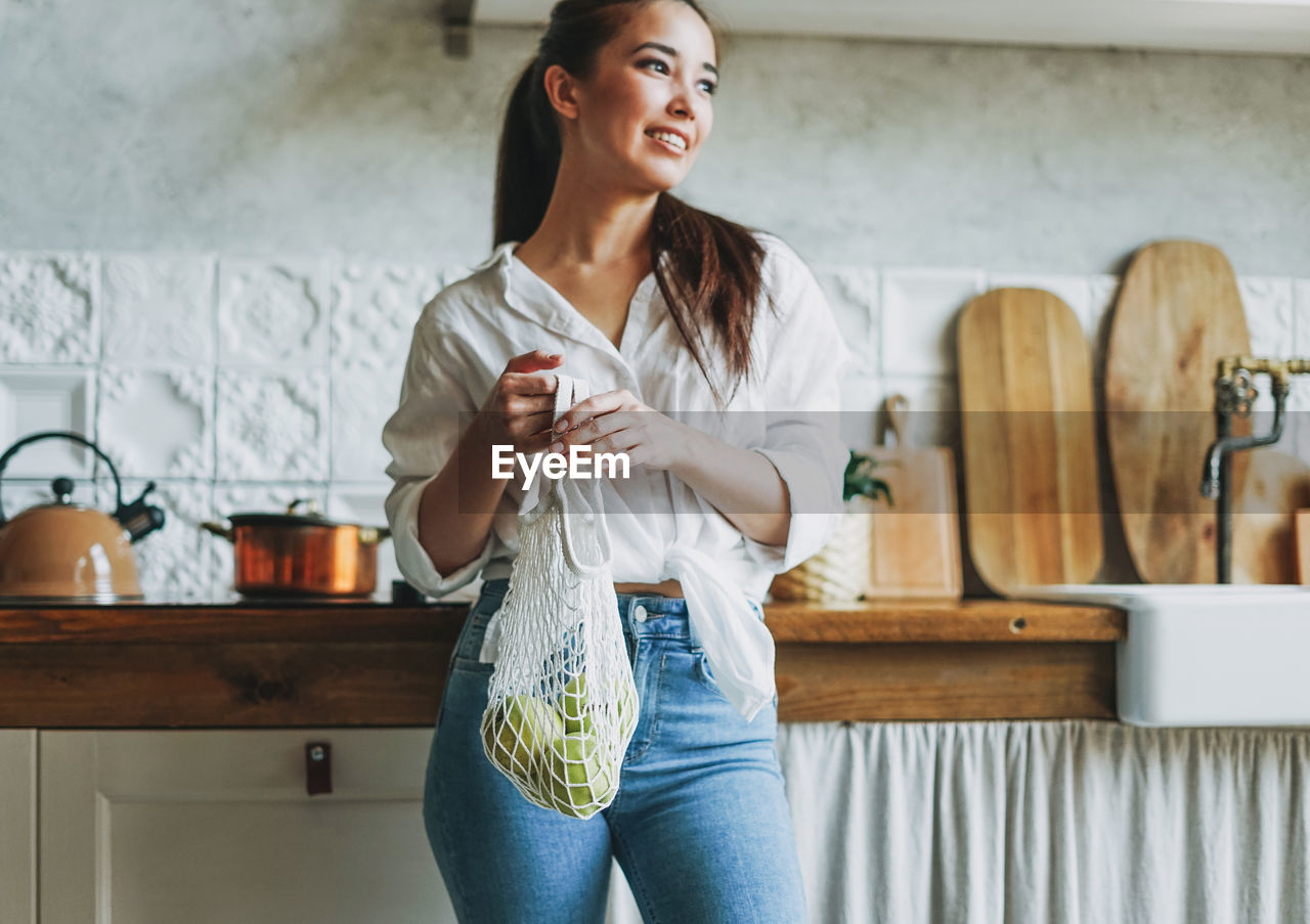 Smiling young woman standing at home