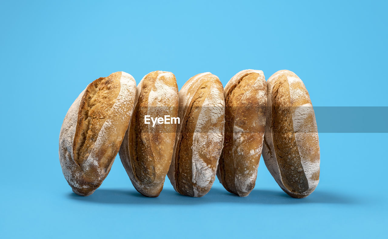 CLOSE-UP OF BREAD AGAINST BLUE BACKGROUND