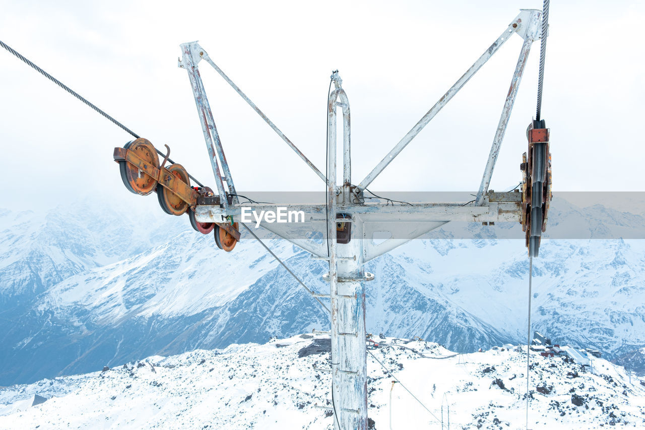 Close-up of the metal structure of the cable car on the background of snowy mountains. ski resort.