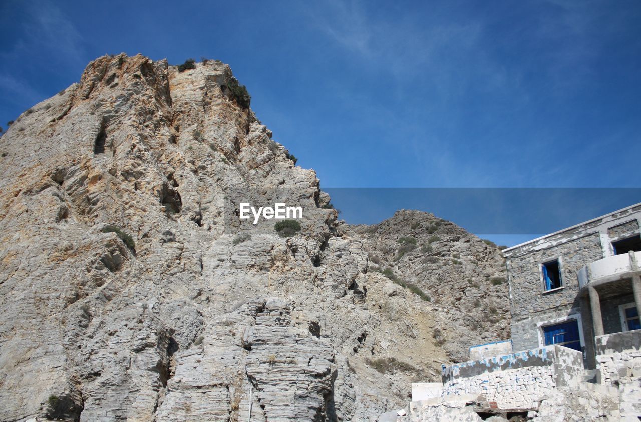 Low angle view of mountain against blue sky