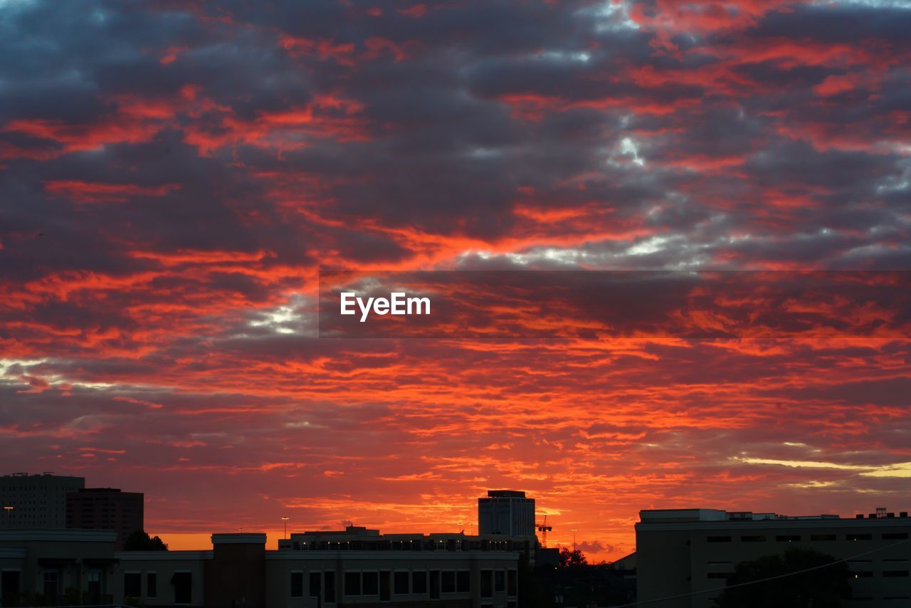 LOW ANGLE VIEW OF SILHOUETTE BUILDINGS AGAINST SKY DURING SUNSET