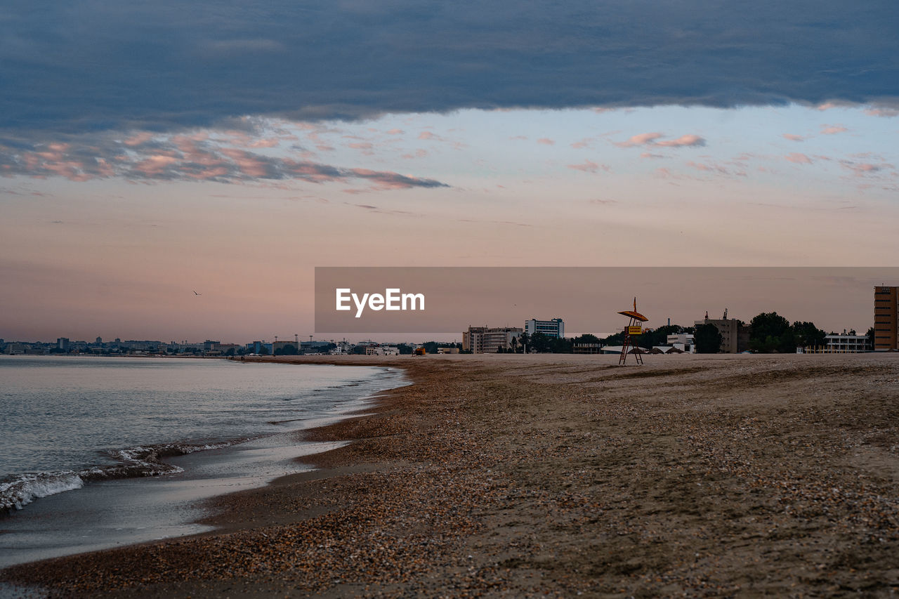 Scenic view of beach against sky during sunrise