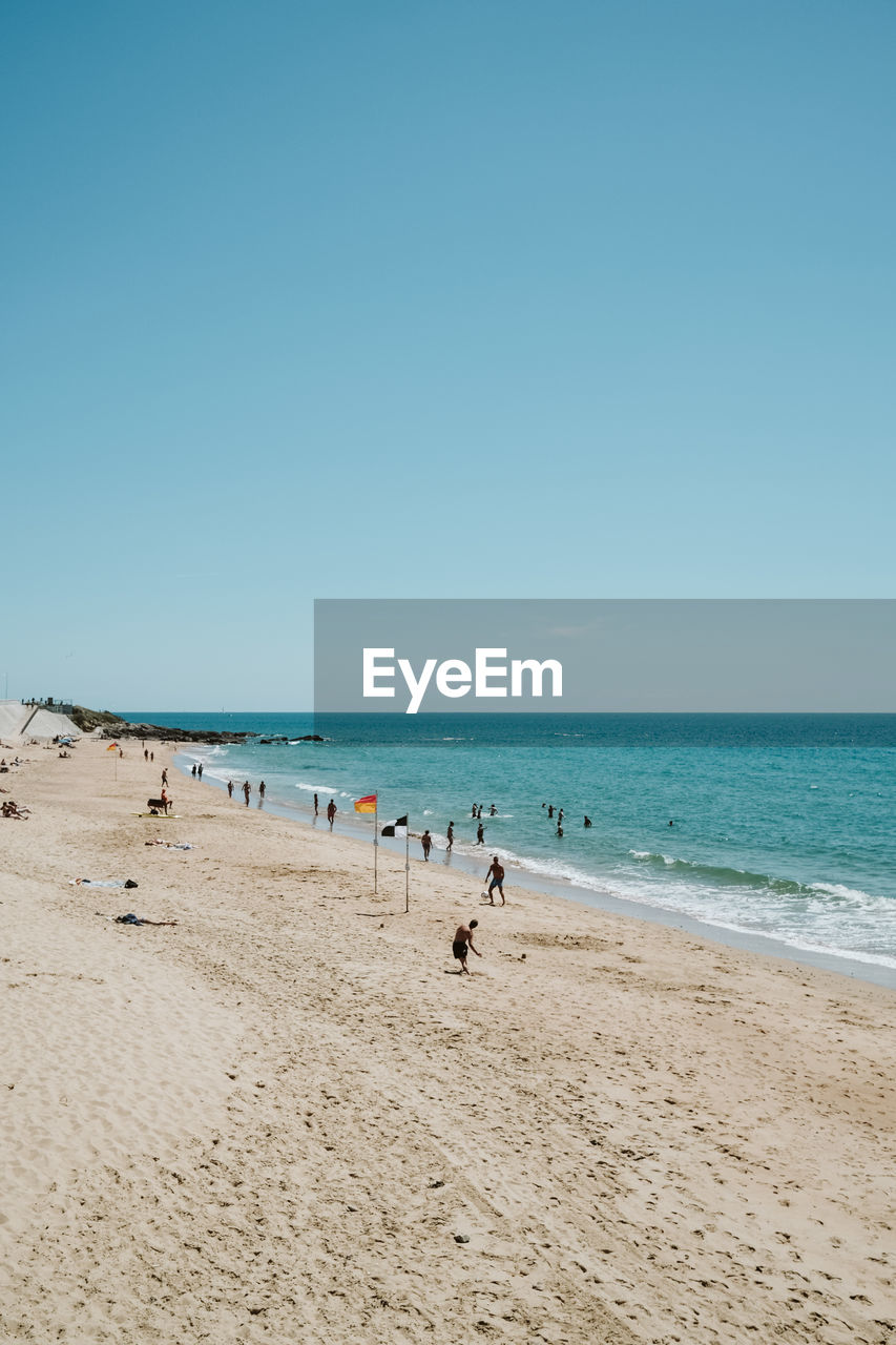 Scenic view of beach against clear blue sky