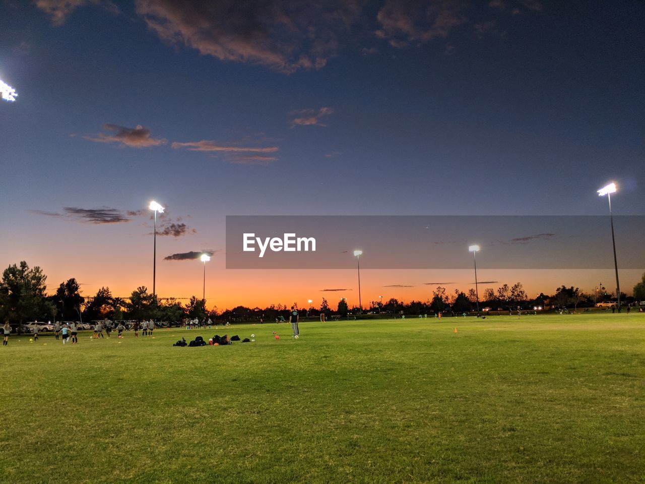 Soccer field against blue sky during sunset