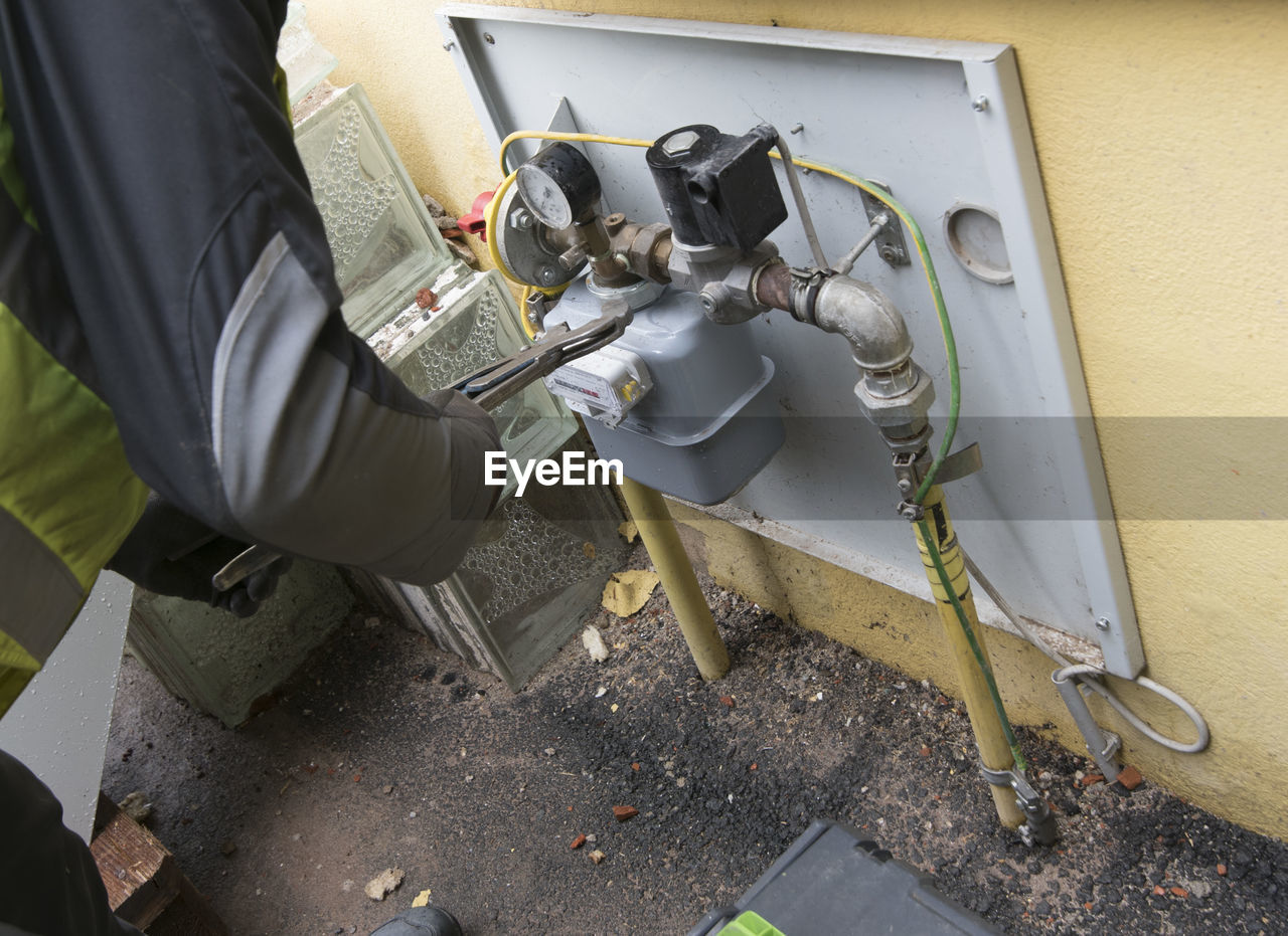 HIGH ANGLE VIEW OF MAN WORKING ON METAL