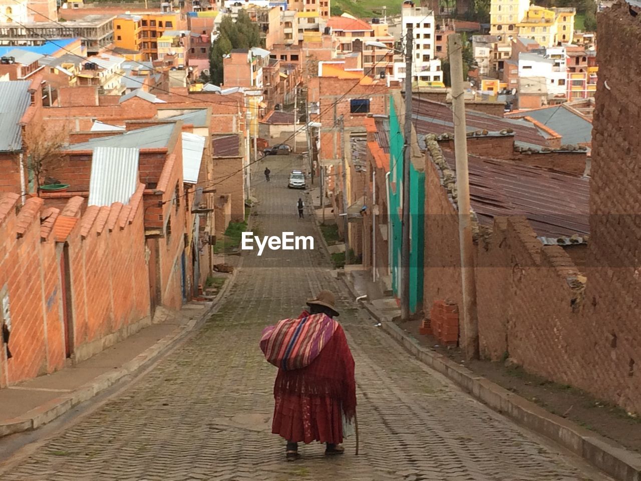 WOMAN WALKING ON COBBLESTONE STREET