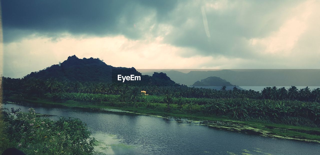 SCENIC VIEW OF RIVER BY MOUNTAIN AGAINST SKY