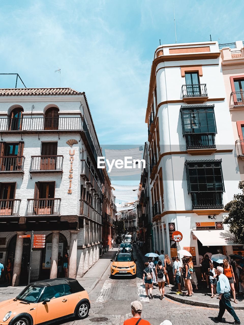 CARS ON STREET BY BUILDINGS AGAINST SKY