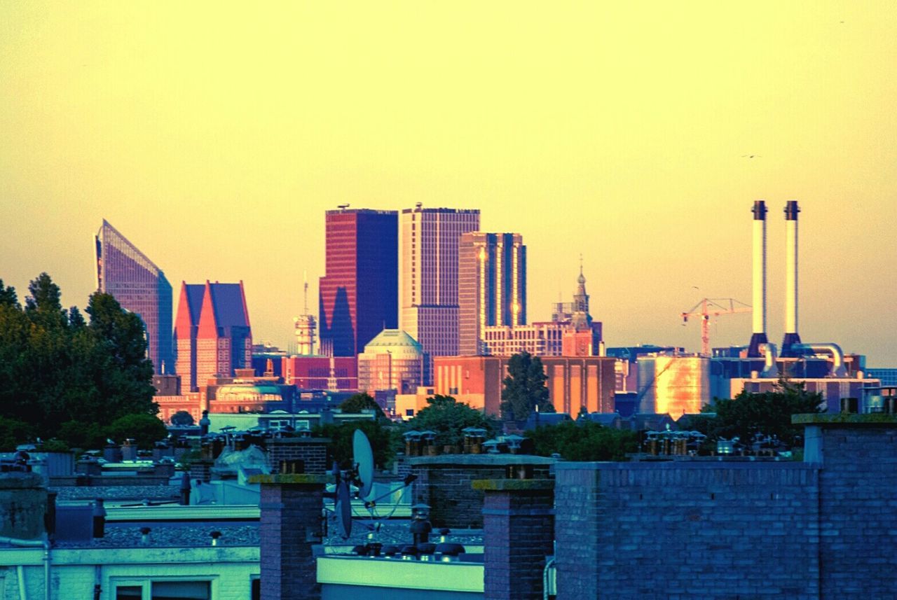 Skyscrapers in city at sunset