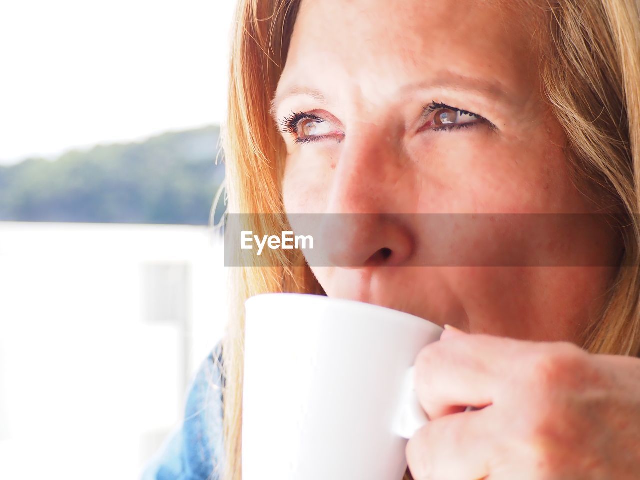 Close-up of thoughtful woman drinking coffee